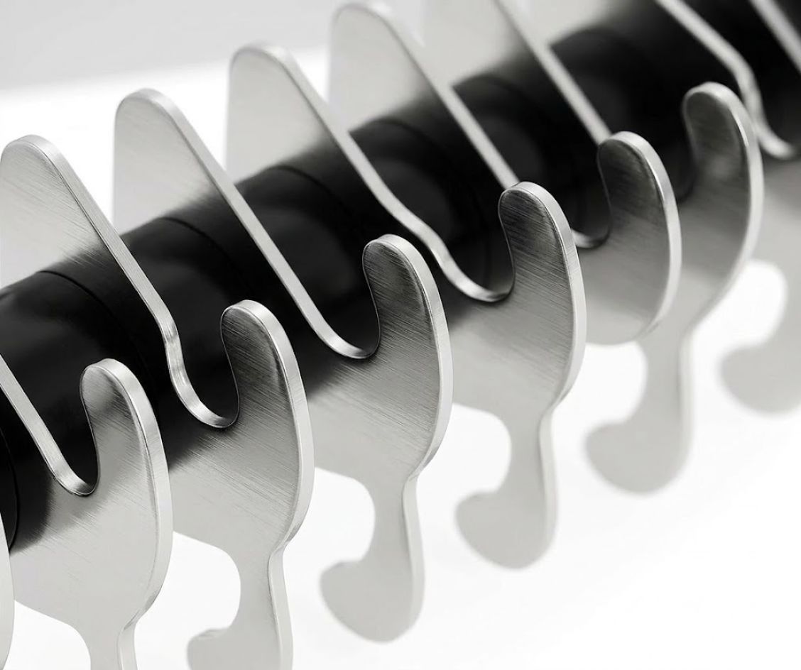 Close-up of a hairbrush with black bristle head and silver metal handle on a white background  CoatRake By ZenPaw